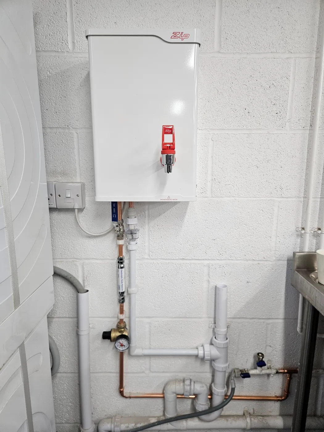 Wall-mounted hot water unit and pipework