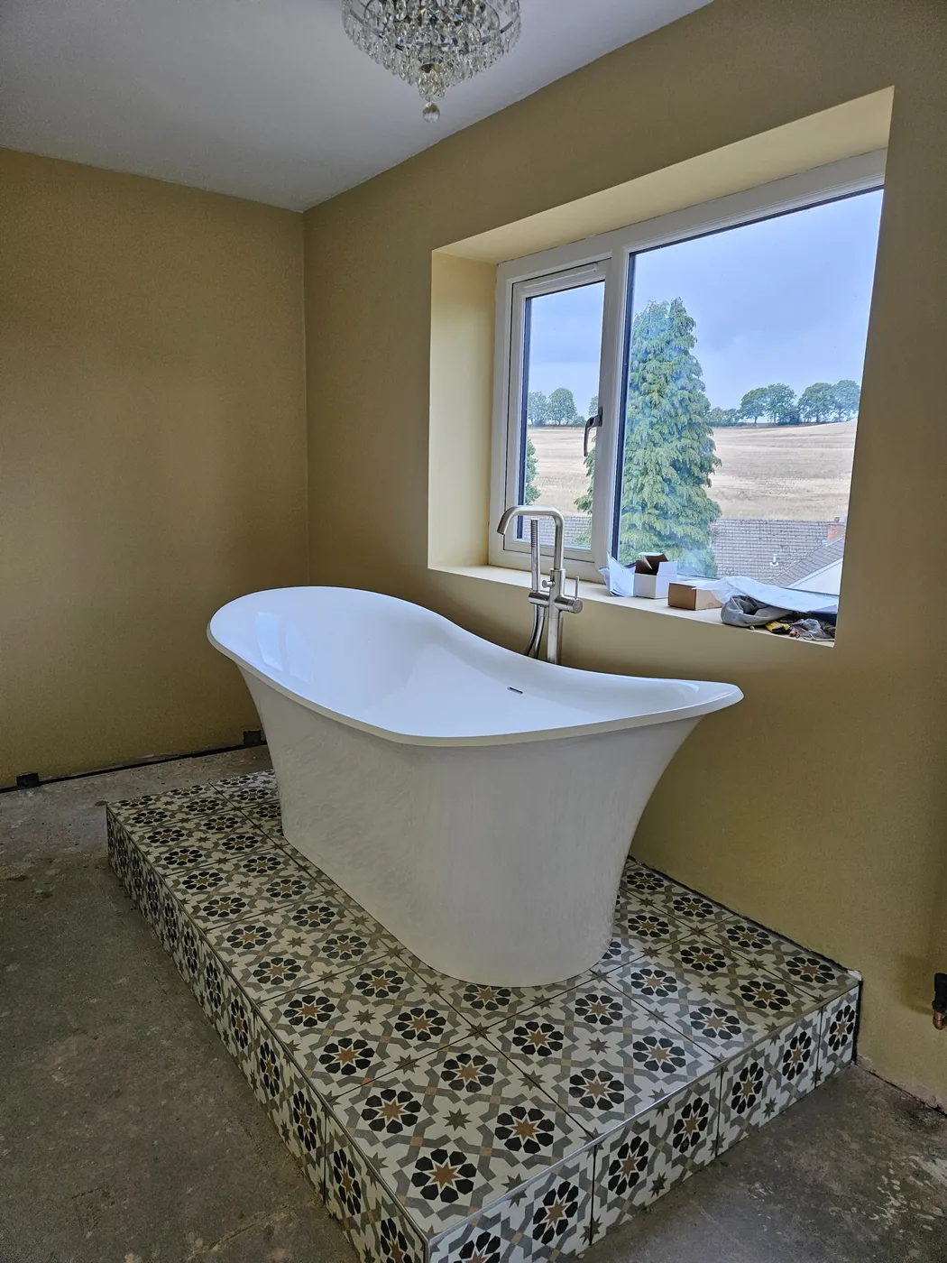 Freestanding bath on a patterned tiled platform
